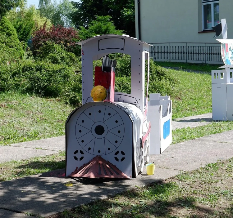 Złożona i pomalowana kartonowa lokomotywa z kolorowymi wzorami namalowanymi przez dzieci.