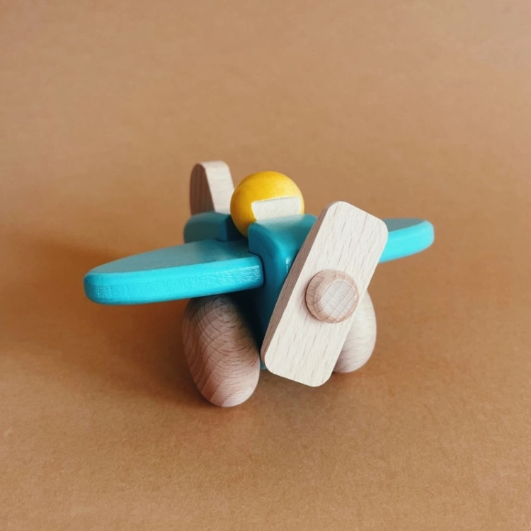 Drewniany samolocik Bajo z żółtym pilotem, widok z przodu.