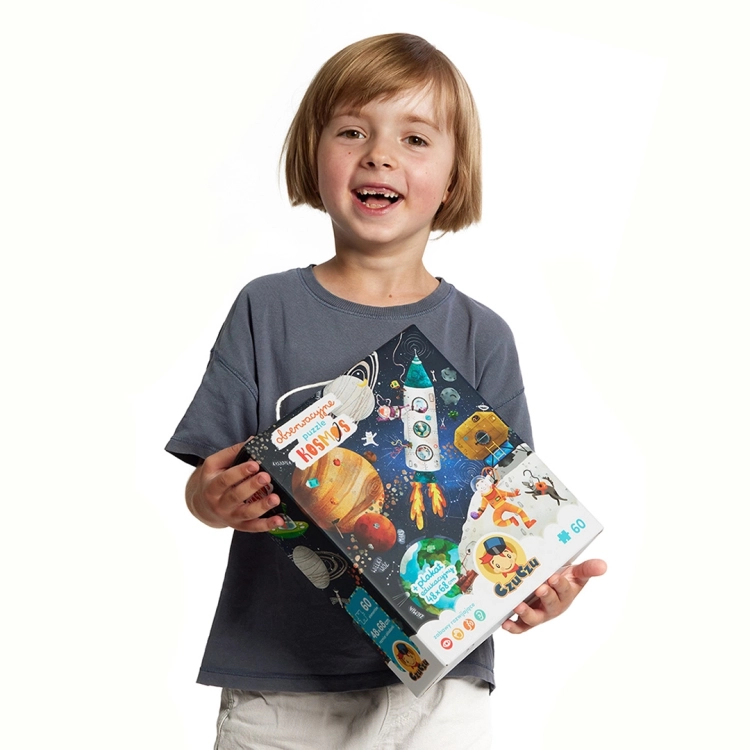 Dziecko trzymające opakowanie puzzli edukacyjnych Kosmos od CzuCzu