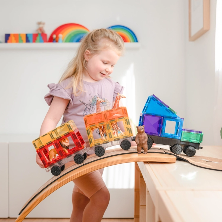 Dziewczynka bawiąca się pojazem z klocków magnetycznych CONNETIX Rainbow Transport Pack