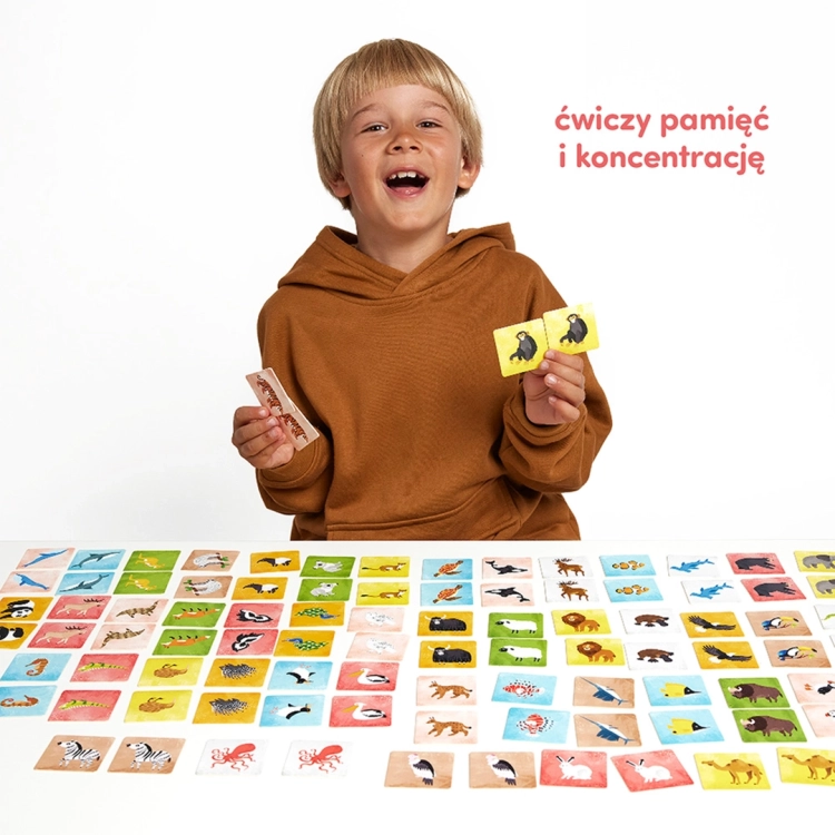 Dziewczynka trzymająca pudełko gry "Memory Zwierzęta świata"