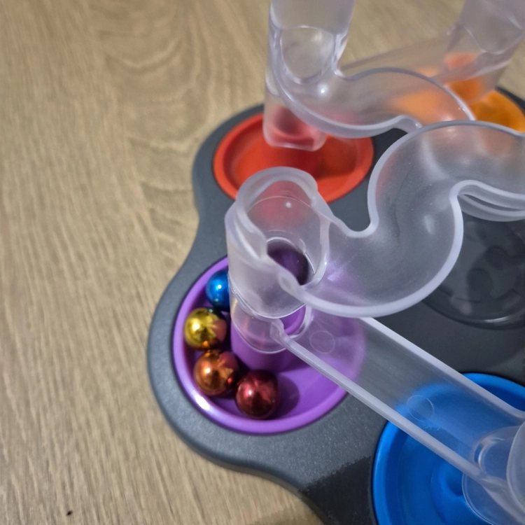 Zbliżenie na transparentne rurki i kulki na planszy gry Dropzone.