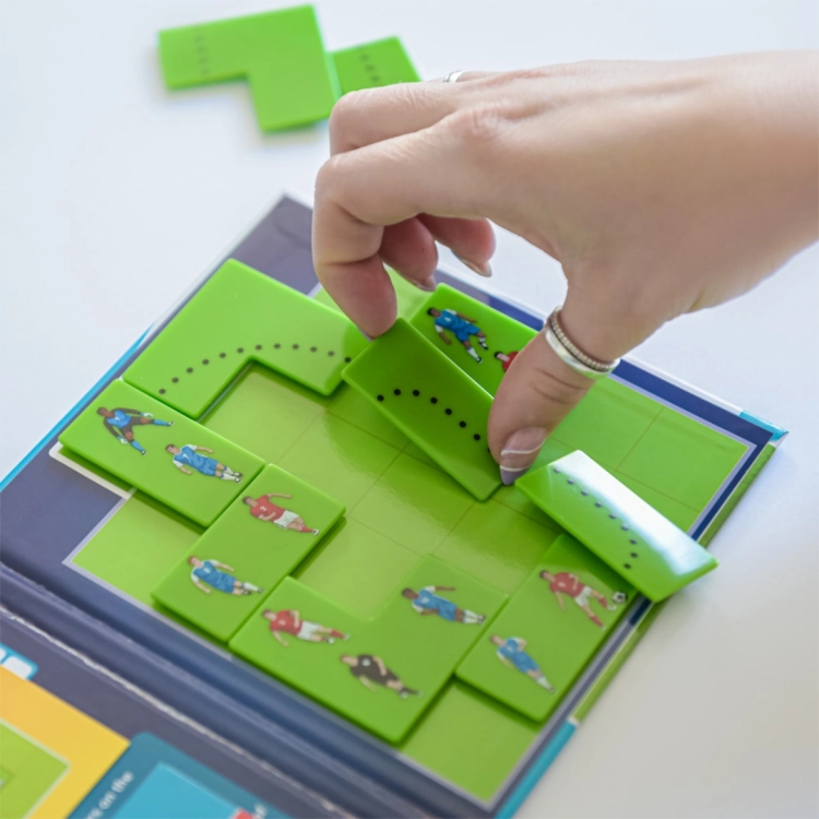 Zbliżenie na układanie puzzli w grze Goool! na magnetycznej planszy.