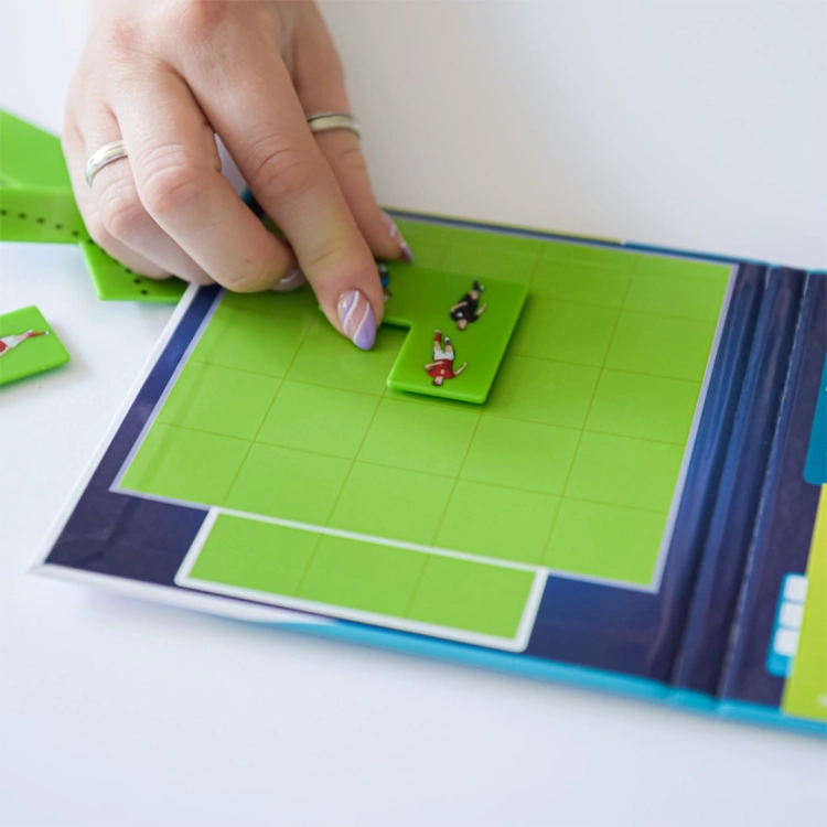 Ręka trzymająca element układanki z gry Goool! z oznaczeniami taktycznymi.