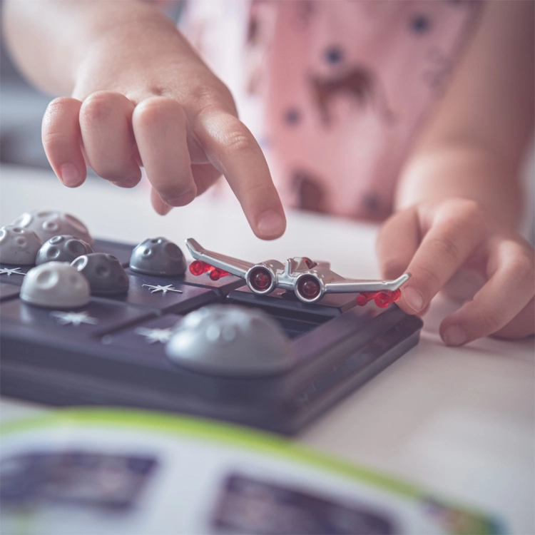 Dziecko przesuwające statek kosmiczny na planszy gry Gwiezdna Ucieczka.