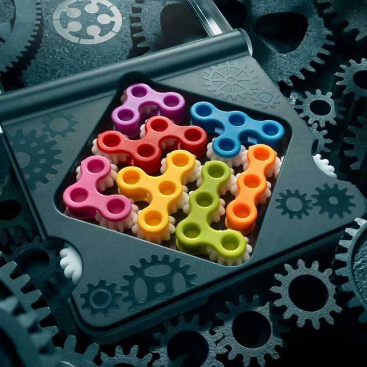 Kolorowe elementy zębate ułożone na planszy IQ Gears.