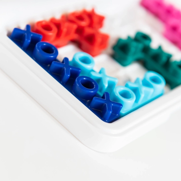 Zbliżenie na kolorowe elementy w kształcie "X" i "O" w grze IQ XOXO.