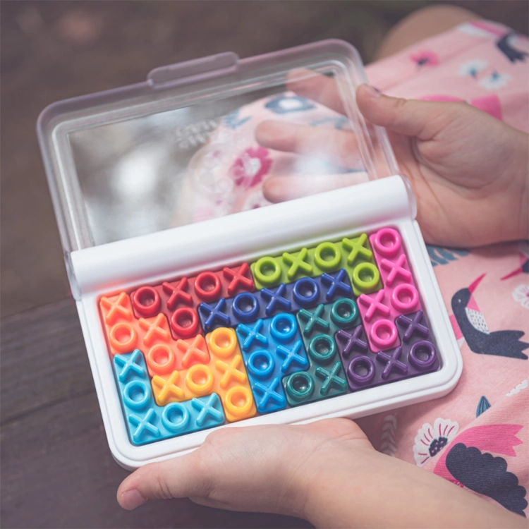 Widok z bliska na ułożone elementy gry IQ XOXO w zamkniętym pojemniku.