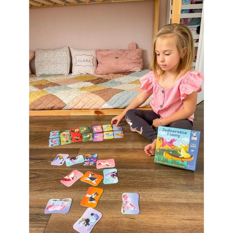 Dziewczynka grająca w Lamy i Jednorożce na podłodze.