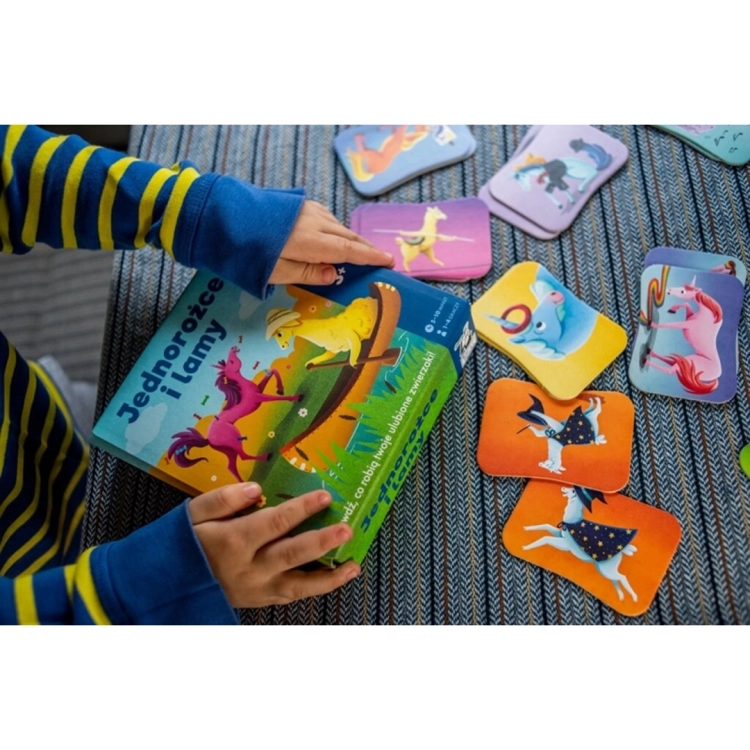 Dziecko otwierające opakowanie gry Lamy i Jednorożce.