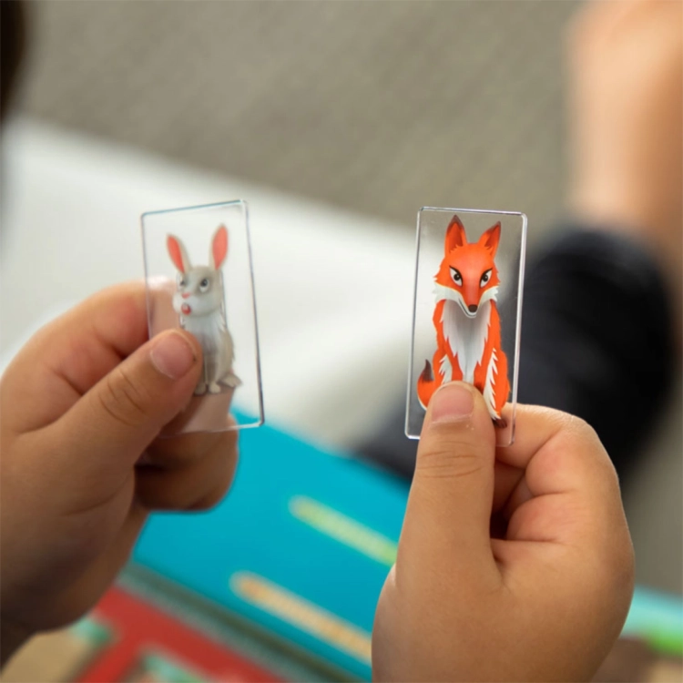 Dziecko trzymające karty z króliczkiem i lisem