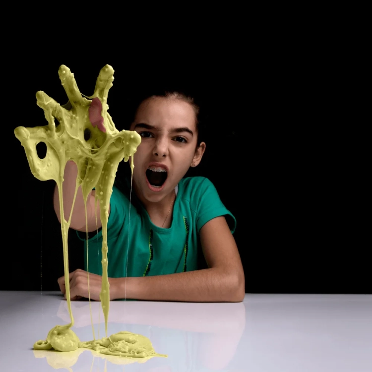 Dziewczynka trzymająca masę plastyczną w zielonym kolorze