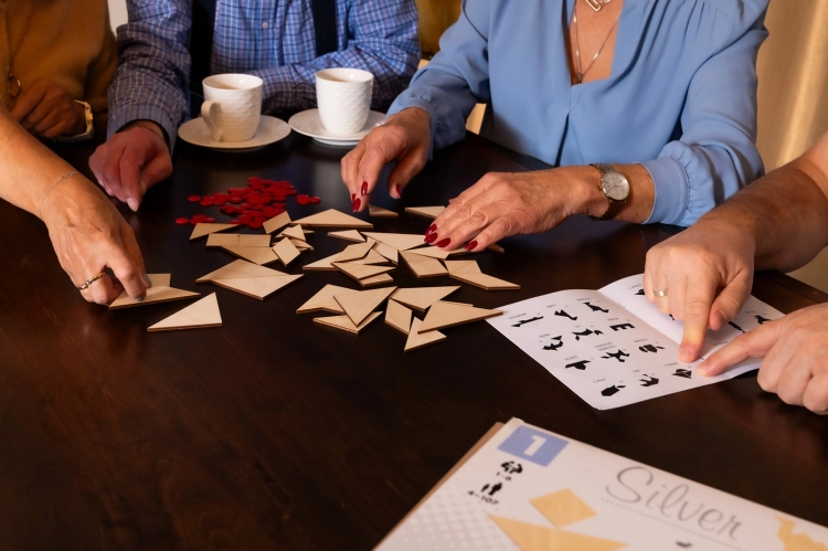 Gracze układający wzory z elementów gry tangram silver.
