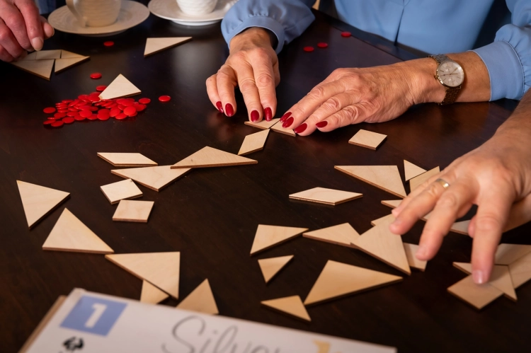 Zbliżenie na dłonie układające figury z elementów tangram silver.