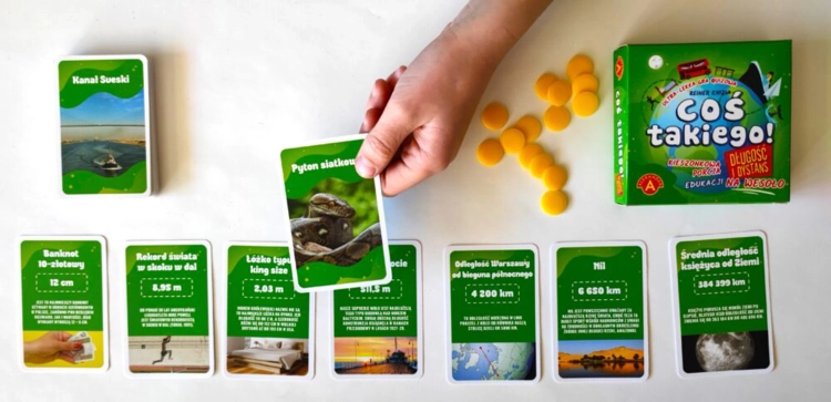 Zbliżenie na karty i żetony gry Coś Takiego! Długość i Dystans.