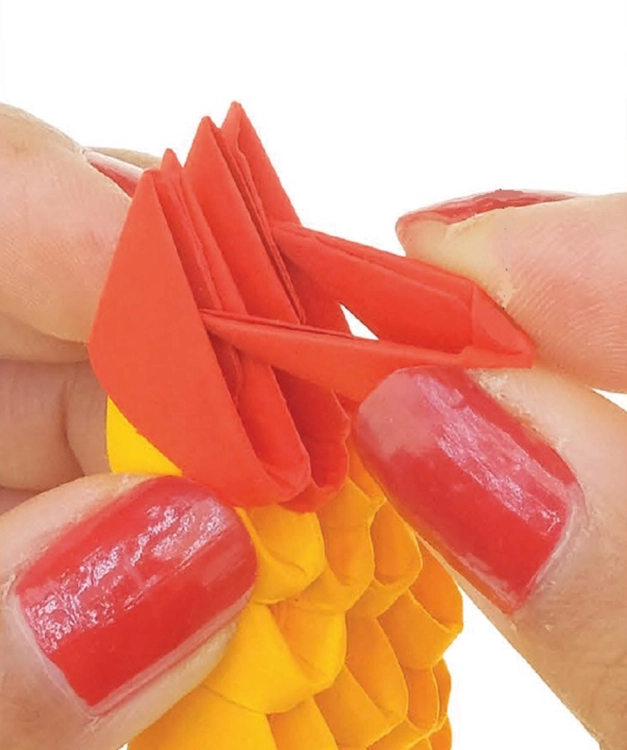 Proces składania modelu Origami 3D - łączenie czerwonych elementów.
