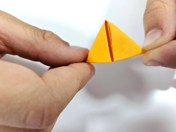 Proces składania ORIGAMI 3D - składanie pomarańczowego modułu w dłoniach.