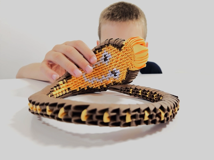 Chłopiec prezentujący ukończony model węża Kobra z zestawu ORIGAMI 3D Alexander.