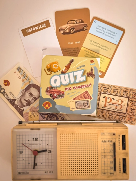 Opakowanie gry edukacyjnej Quiz Kto Pamięta? od Alexander na tle charakterystycznych gadżetów z PRL