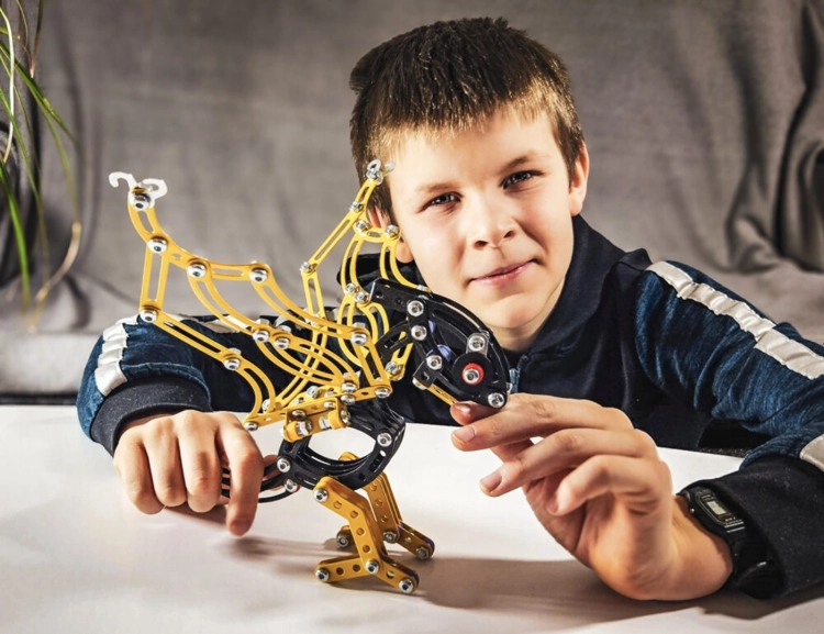 Chłopiec prezentuje gotowy model Pterodaktyla Mały Konstruktor.