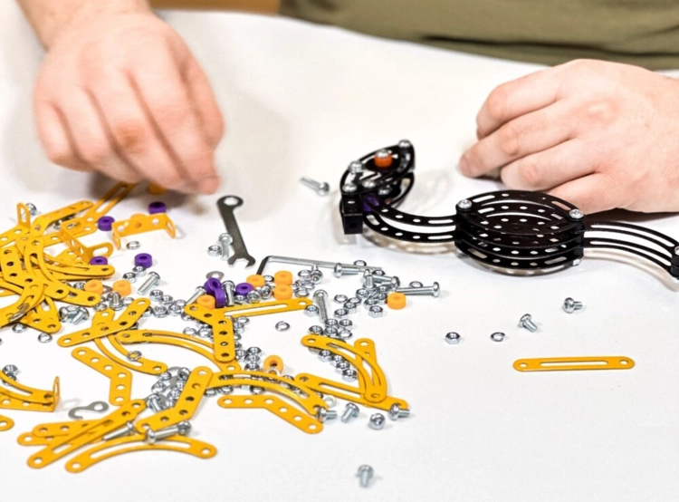 Proces składania Pterodaktyla z elementów metalowych i śrubek.