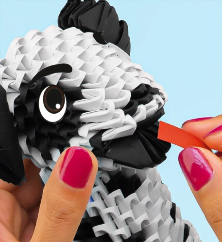 Dziecko składające model origami 3D dalmatyńczyka