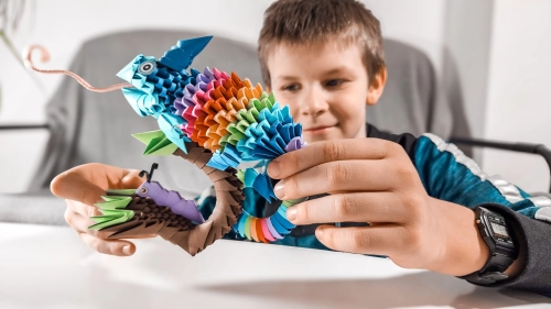 Chłopiec bawiący się  ORIGAMI 3D Kameleon od Alxander