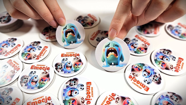 Rozgrywka w grę Memosy – Emocje, dziecięce dłonie odkrywają karty.
