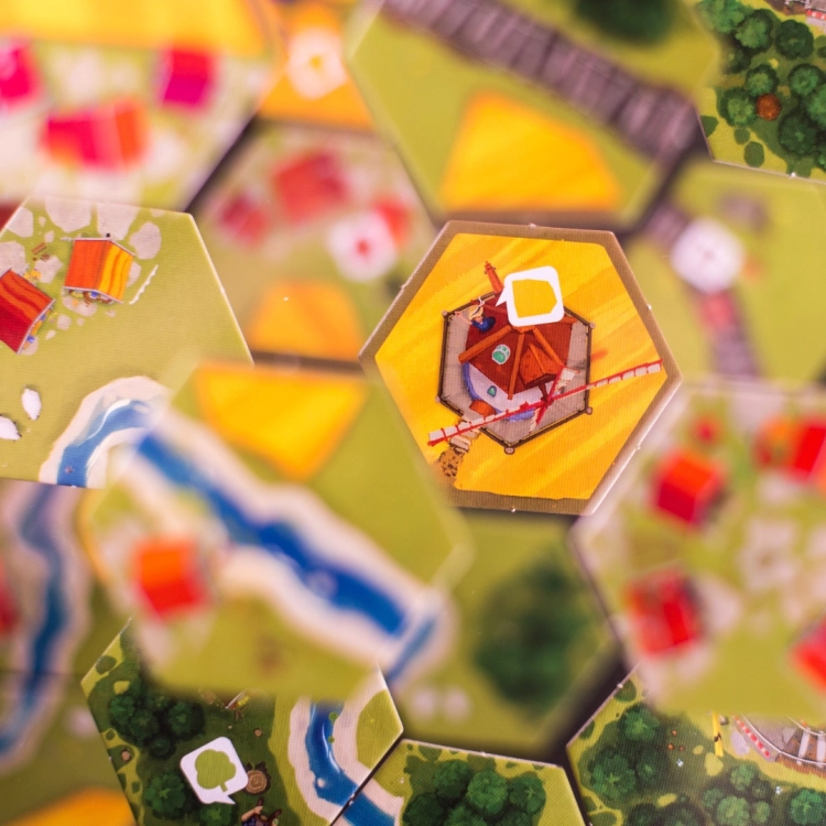 Zbliżenie na kafelek z młynem w grze Dorfromantik – Pojedynczy kafelek z ilustracją młyna otoczonego polami.