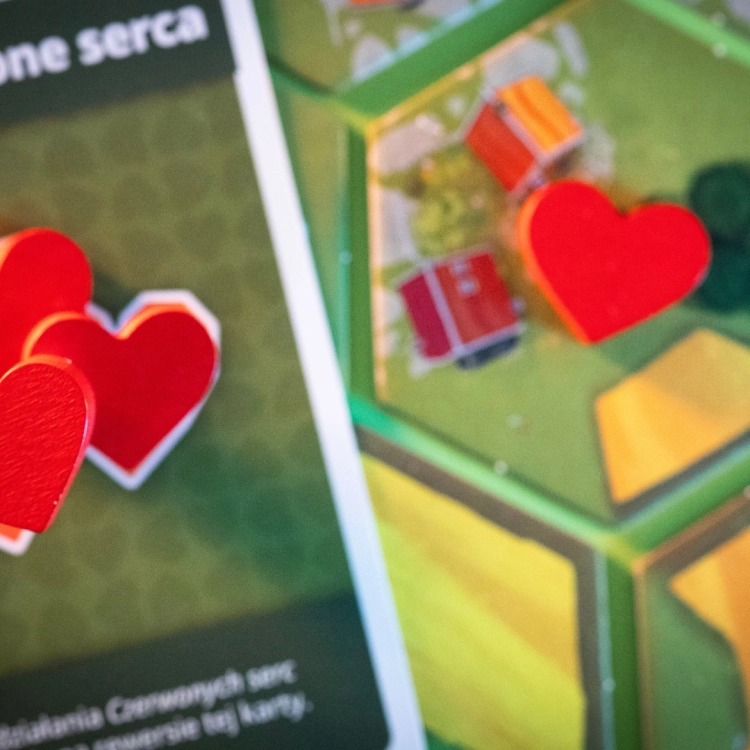Drewniane serca w grze Dorfromantik – Czerwone drewniane serca jako element rozgrywki na tle kafelków.
