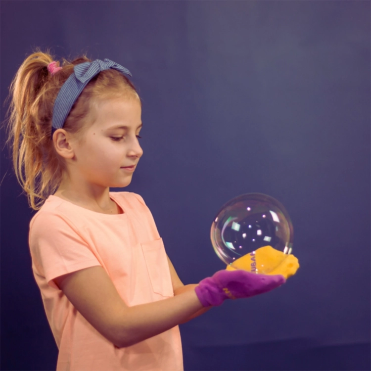 Dziewczynka bawiąca się bańką mydlaną przy użyciu zestawu Tuban
