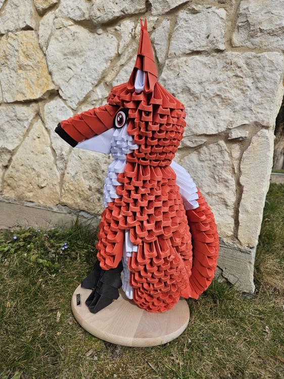 Papierowa figurka Lis z origami stojąca w ogrodzie