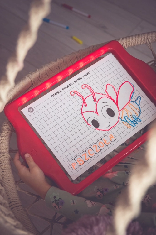 Dziecko trzymające tablicę LED Carotina z obrysem pszczoły