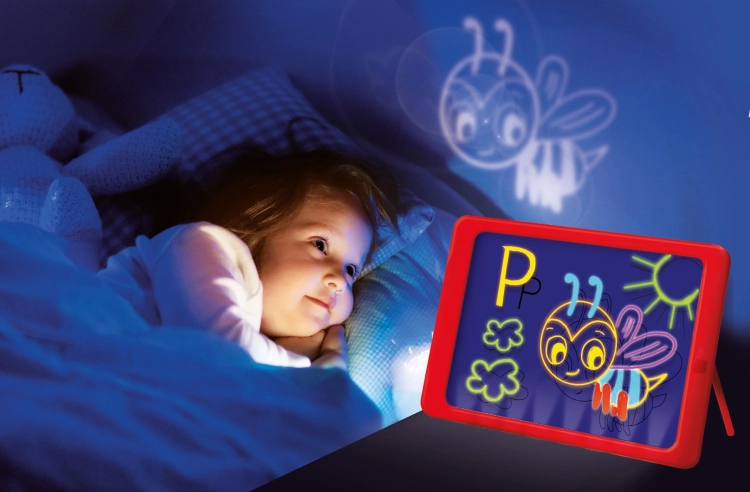 Dziewczynka w łóżku patrząca na rysunek wyświetlany na ścianie z tablicy LED Carotina