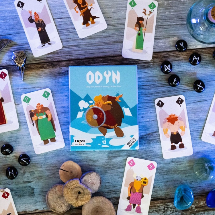 Zestaw gry Odyn – pudełko gry otoczone rozłożonymi kartami, elementami i znacznikami.