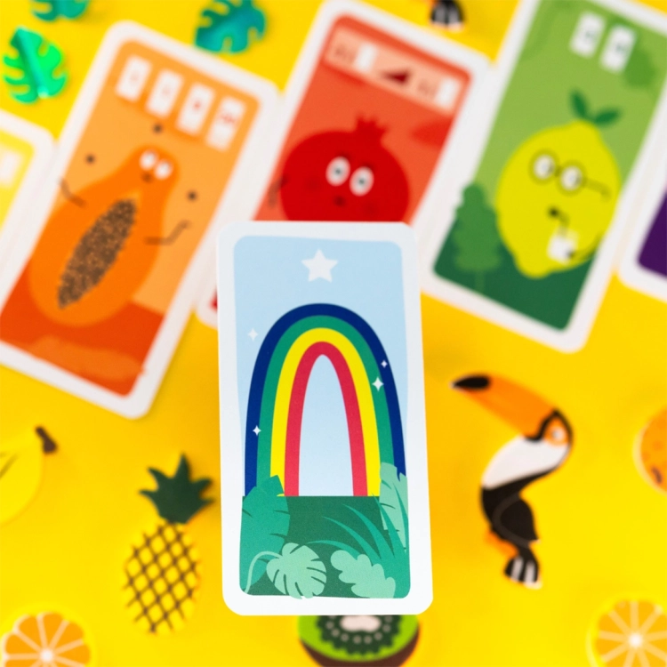 Tęczowa karta specjalna z Tucano – Karta specjalna z tęczą w otoczeniu kart owoców z gry Tucano.