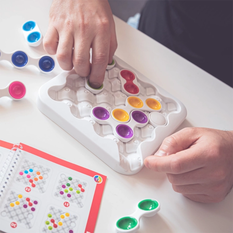 Gracz przesuwa kolorowe elementy na planszy w grze Antywirus SmartGames.