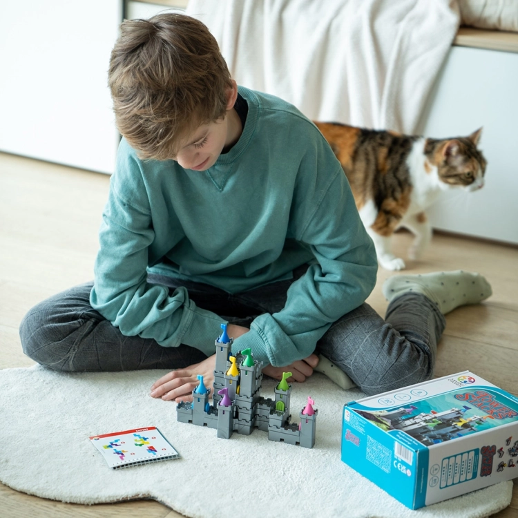 Dziecko buduje konstrukcję zamku z gry Baszty i Maszty SmartGames.