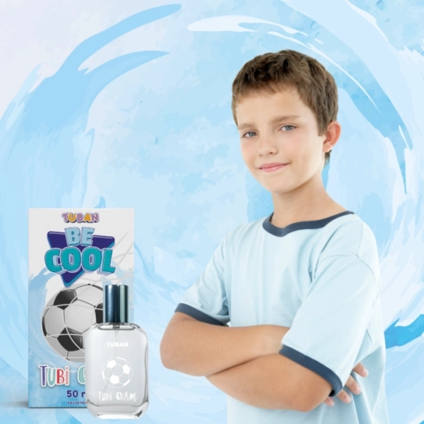 Chłopiec w błękitnej koszulce z perfumami Tubi Glam Be Cool i opakowaniem z motywem piłki nożnej