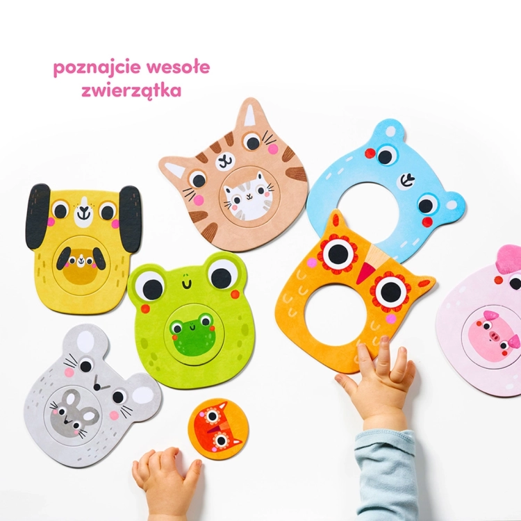 Rozłożone na białym tle kolorowe puzzle z motywami zwierzątek i rączki dziecka w trakcie zabawy.