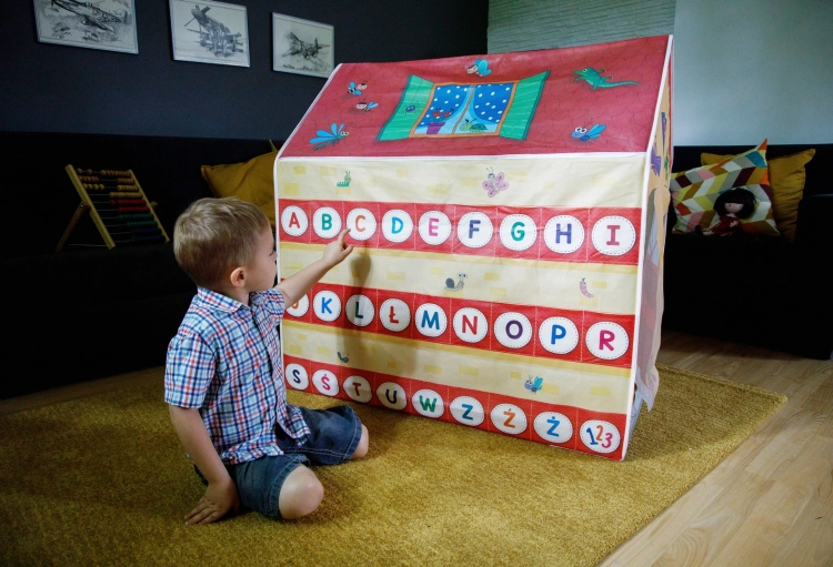 Chłopiec bawiący się przy domku Montessori