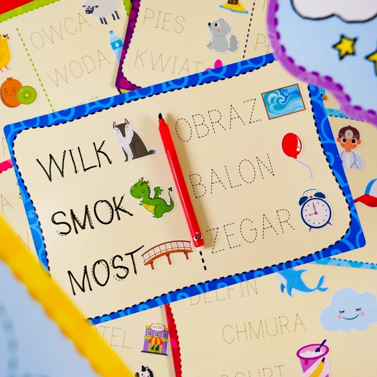 Plansze z wyrazami i ilustracjami, długopis leżący na tabliczce z wyrazami wilk, smok, obraz.
