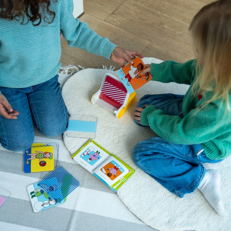 Dwoje dzieci wspólnie rozwiązuje zadanie z gry Dress Code – ubieranie do pogody.