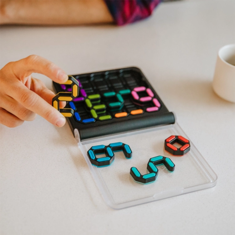 Dłoń układająca kolorowe cyfry w grze logicznej IQ Digits Smart Games.