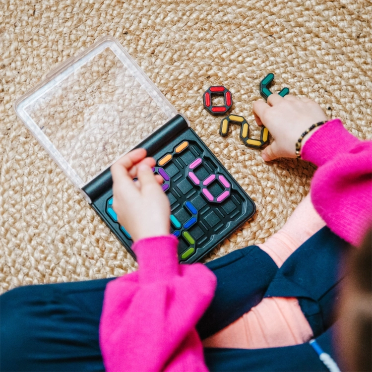 Ręce dziecka dopasowujące kolorowe cyfry IQ Digits na macie.