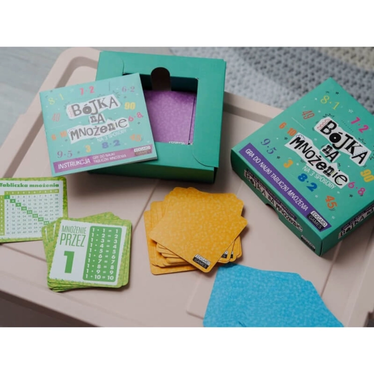 Otwarta gra Bójka na mnożenie z widocznymi kartami i instrukcją na stole.