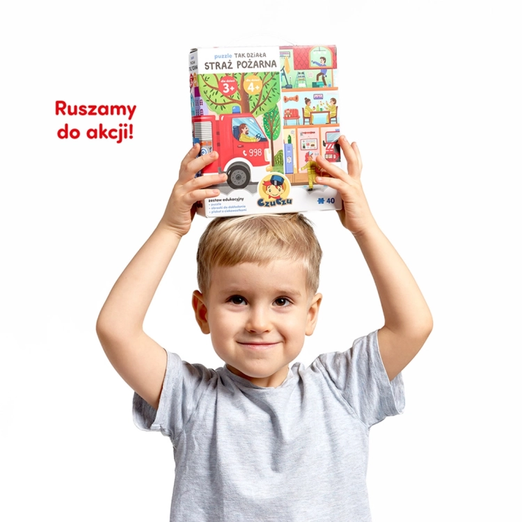 Chłopiec trzymający pudełko puzzli Tak działa straż pożarna od CzuCzu nad głową