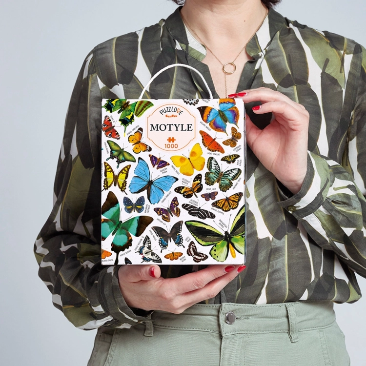 Kobieta trzyma pudełko puzzli Puzzlove Motyle CzuCzu 1000 elementów