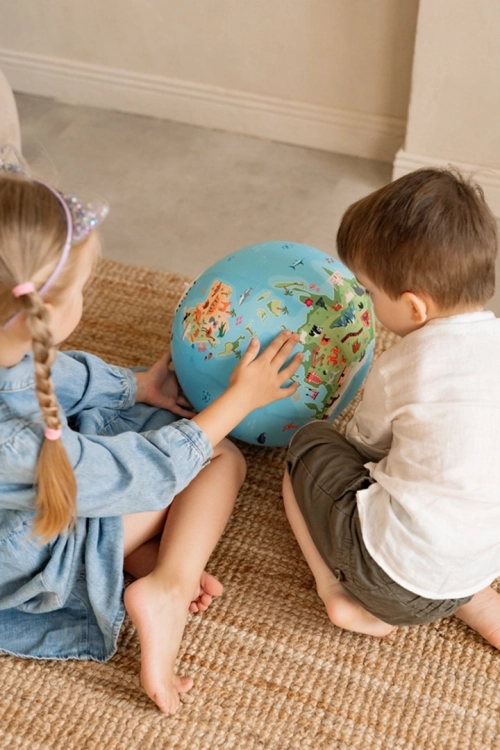 Dzieci bawiące się piłką balonową z mapą świata i zwierzętami AKSON