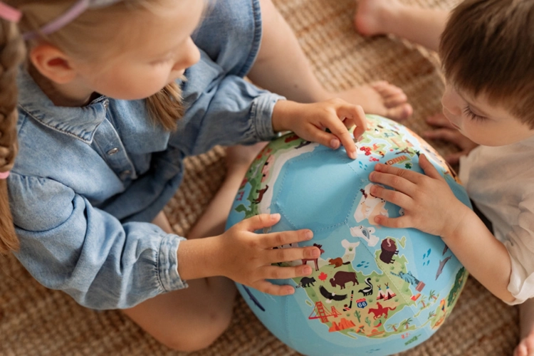 Dzieci oglądające kontynenty i zwierzęta na piłce balonowej AKSON